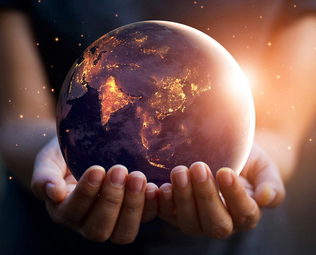 Earth at night held in human hands. Elements of this image furnished by NASA. Credit: PopTika / Shutterstock.